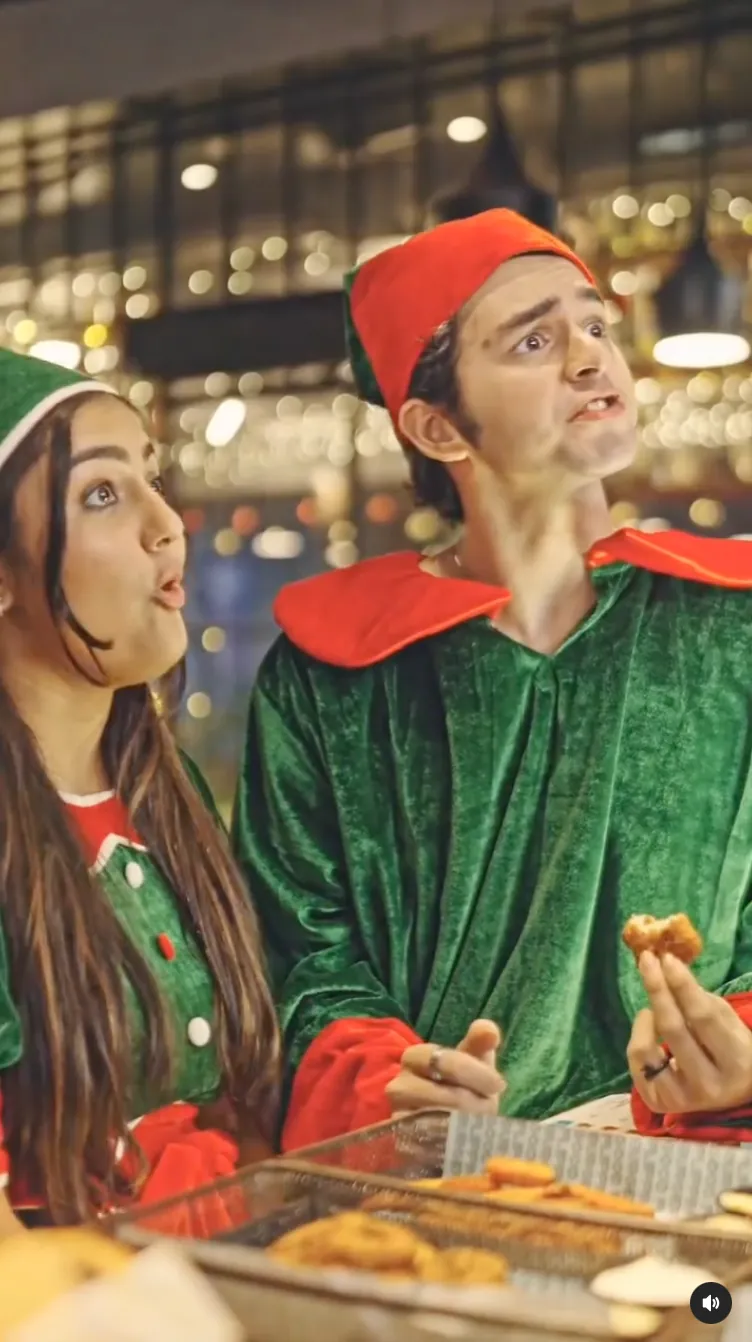 Two friends dressed as Christmas elves eating fries